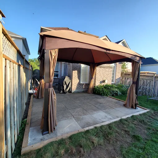 Backyard gazebo set on a newly poured stone patio pad in Oshawa