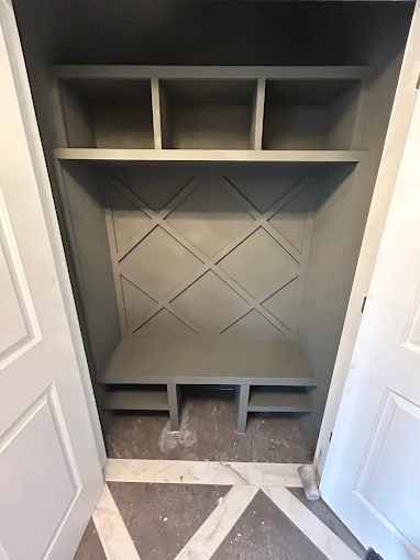 Built-in mudroom bench with cubbies and X-pattern panelling
